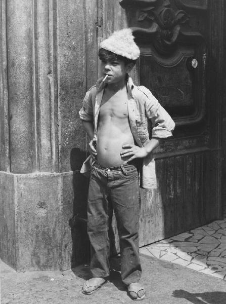 Napoli: Seconda scelta. Napoli - Vicoli - Ritratto infantile - Bambino con camicia aperta, cappello di pelo - Sigaretta