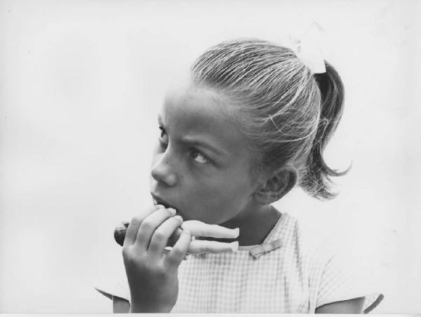 Napoli: Bimbi, volti. Napoli - Esterno - Ritratto infantile - Bambina con bambolina in bocca