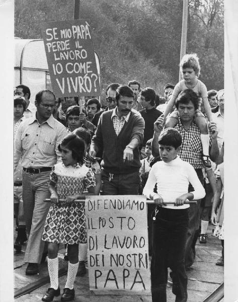 Manifestazioni contro licenziamenti Innocenti. Milano - Manifestazione operaia, sciopero - Corteo operai Innocenti con famiglie - Cartelli di protesta contro i licenziamenti