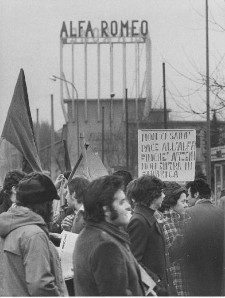 Potere Operaio, Lotta Continua, Pantere Bianche. Milano: Portello - Stabilimento Alfa Romeo, esterno - Manifestazione Potere Operaio - Gruppo di operai - Cartello di protesta