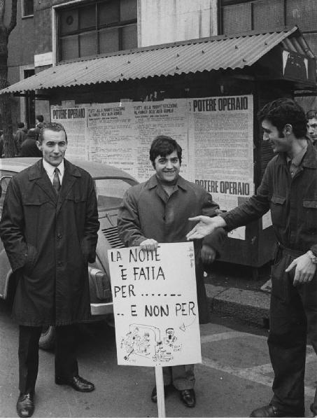 Potere Operaio, Lotta Continua, Pantere Bianche. Milano: Portello - Stabilimento Alfa Romeo, esterno - Ritratto di gruppo - Uomo con cartello di protesta - Operaio, tuta da lavoro - Potere Operaio