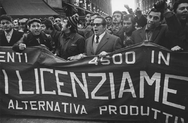 Italia: manifestazioni operaie. Milano, galleria Vittorio Emanuele II - Manifestazione operaia - Corteo degli operai della Leyland Innocenti in tuta da lavoro - Striscione contro i licenziamenti