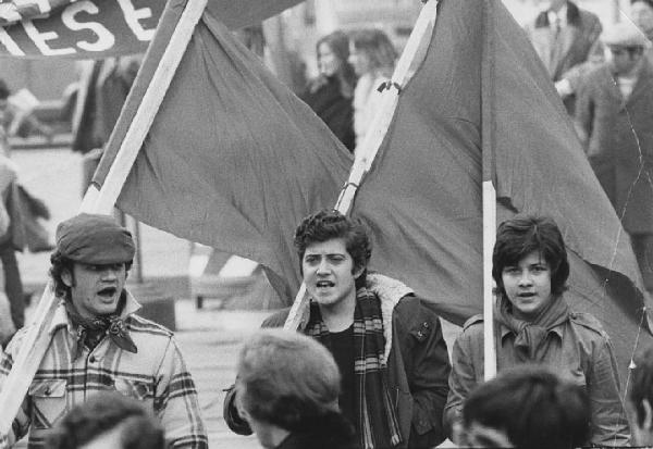 Manifestazioni anni '70. Milano, piazza Santo Stefano - Manifestazione studentesca - Ritratto di gruppo: ragazzi con bandiere