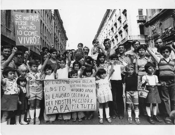 Italia: manifestazioni operaie. Milano - Manifestazione operaia contro i licenziamenti Leyland Innocenti - Ritratto di gruppo - Adulti e bambini, famiglie di operai - Cartelli di protesta