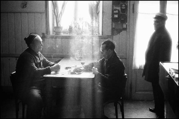 Milano - Via Oldofredi 21 - "Osteria del Gaitto", interno - Ritratto di gruppo: uomini seduti ad un tavolo, uomo in piedi davanti alla porta - Gioco delle carte - Finestra - Fumo