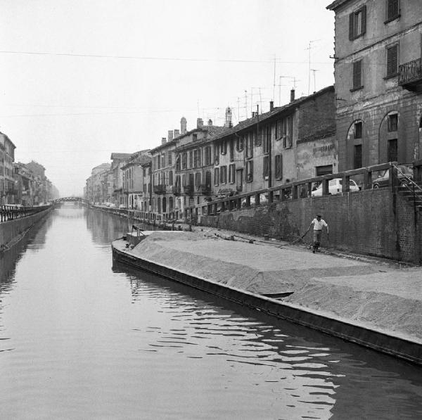 Milano - Alzaia Naviglio Grande - Uomo su un barcone - Edifici - Automobili - Ponte - Acqua