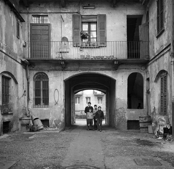 Milano - Via Ascanio Sforza 29 - Casa di ringhiera, cortile interno - Ritratto infantile di gruppo: quattro bambini - Ballatoio con piante in vaso