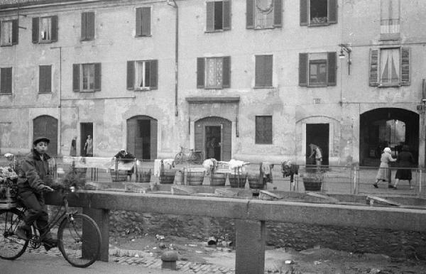 Milano, Via Ascanio Sforza 25, Naviglio Pavese - Strada - Ritratto infantile: bambino in bici - Ritratto femminile: donne lavandaie - Catini di legno per il bucato - Panni - Case di ringhiera, facciata esterna