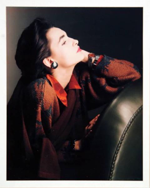 Campagna pubblicitaria per Trussardi Donna - Modella di profilo - Mano che sostiene il volto: maglione in toni autunnali e orecchino metallico