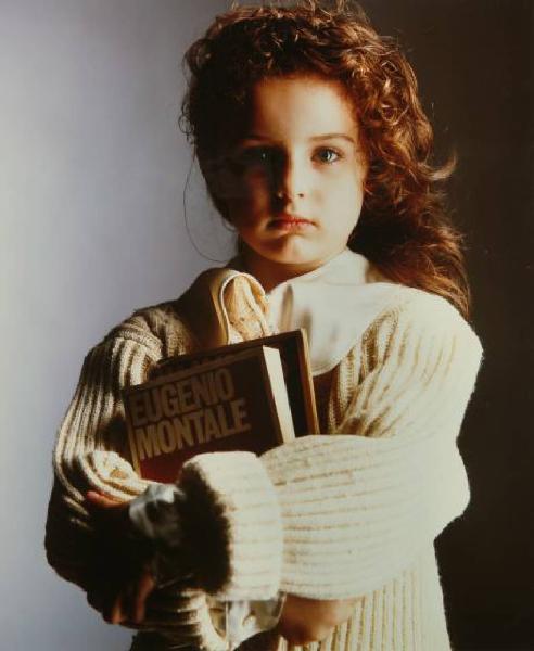Campagna pubblicitaria per Trussardi Junior - Bambina con maglione a coste bianco - Libro di Eugenio Montale