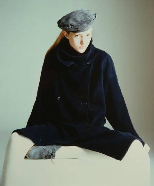 Campagna pubblicitaria per Trussardi Donna - Modella seduta: cappotto di velluto blu su calze bianche - Basco scamosciato coordinato con le scarpe stringate