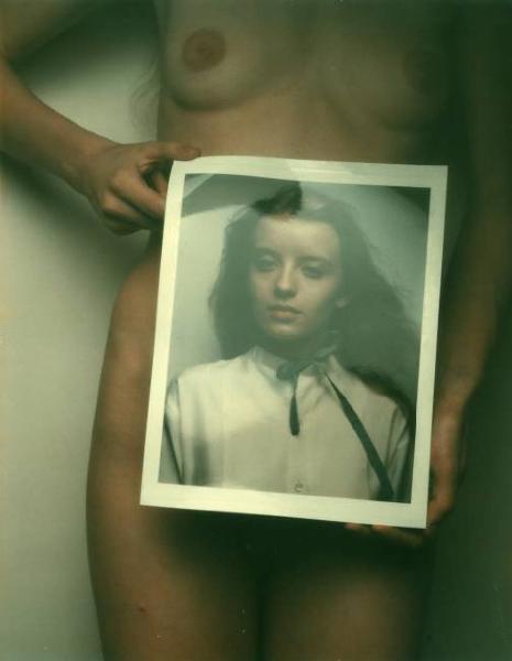 Nudo femminile - giovane donna si copre le parti intime con la fotografia di un volto femminile