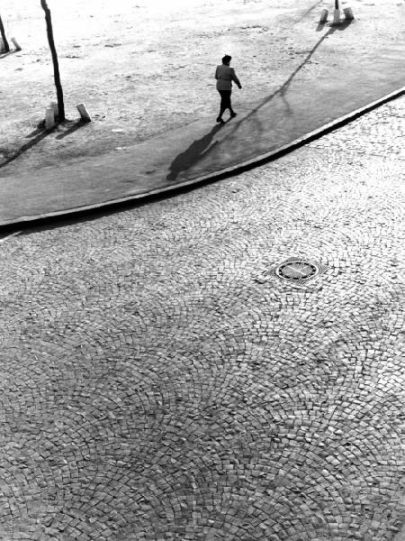 Selciato - tombino - donna cammina sul marciapiede