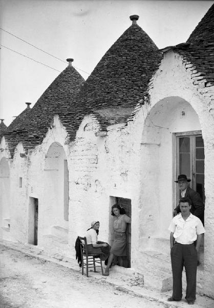 Italia del Sud. Puglia - Alberobello - persone sulla soglia dei trulli