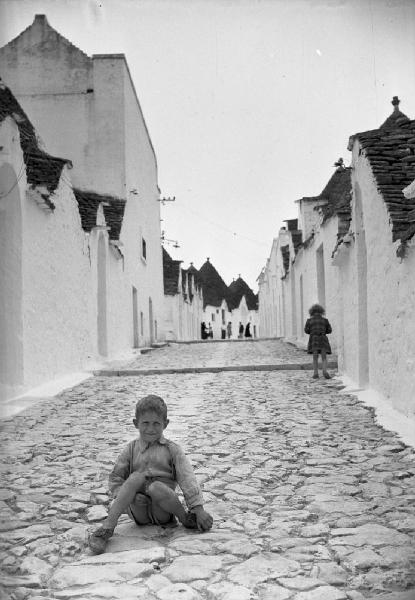 Italia del Sud. Puglia - Alberobello - strada lastricata - bambino