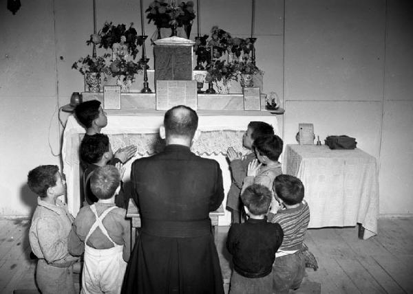 Italia del Sud. Puglia - Bari - Villaggio dei Fanciulli - bambini in preghiera - prete