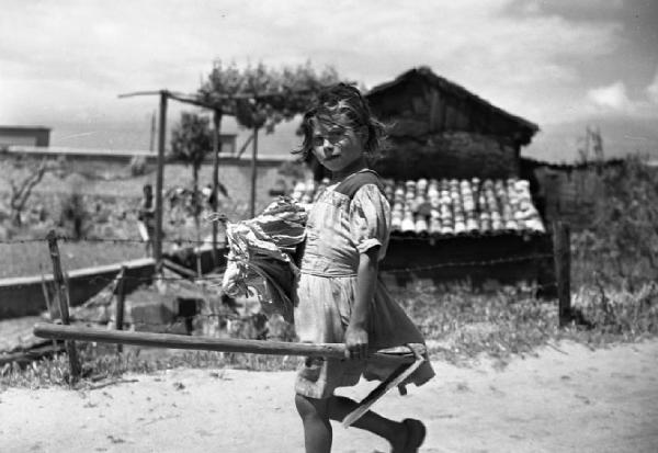 Italia del Sud. Calabria - bambina reca un attrezzo agricolo