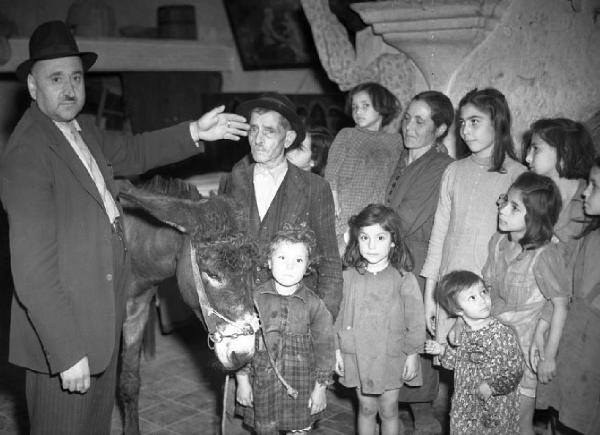 Italia del Sud. Bernalda - ritratto di gruppo - uomo mostra la propria famiglia - moglie e figli