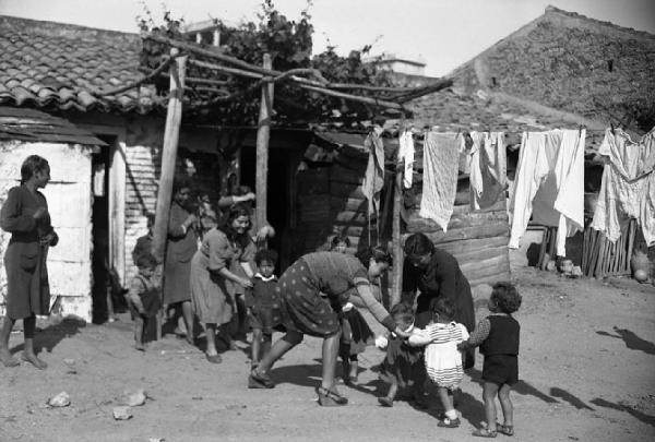 Italia del Sud. Calabria - Paese - Scuola - Maestre con bambini - Gioco - Baracche - Panni stesi