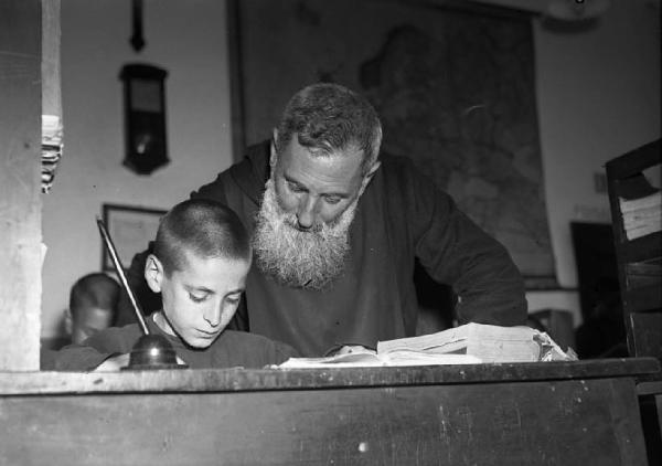 Italia del Sud. Calabria - Scuola: interno - Prete ortodosso e bambino - Banco con calamaio