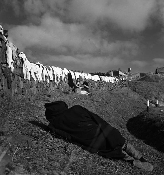 Italia del Sud. Sardegna - Barbagia di Belvì - biancheria stesa ad asciugare su un muretto a secco - uomo che dorme