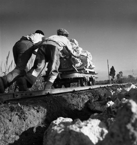 Italia del Sud. Sardegna - costruzione della ferrovia Nuoro-Macomer - operai spingono un carrello carico di pietre