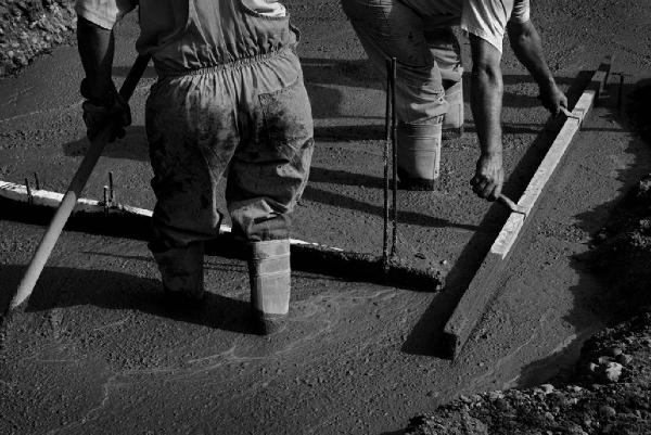 Tramsformazione. Milano - Cinisello Balsamo - Cantiere della metrotranvia - Particolare di due operai con le gambe nel cemento