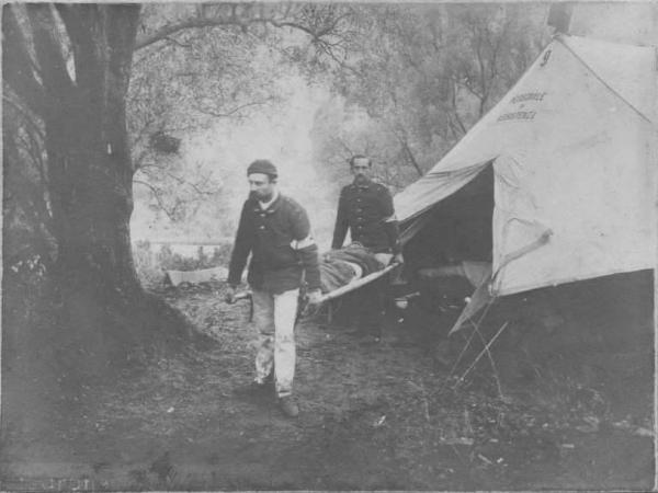 Croce Rossa Italiana - Ospedale da Guerra n. 7 - Accampamento -- San Roberto / Ferito - Trasporto con barella da parte del personale del Corpo Militare del Sotto Comitato di Sezione di Bergamo della Croce Rossa Italiana