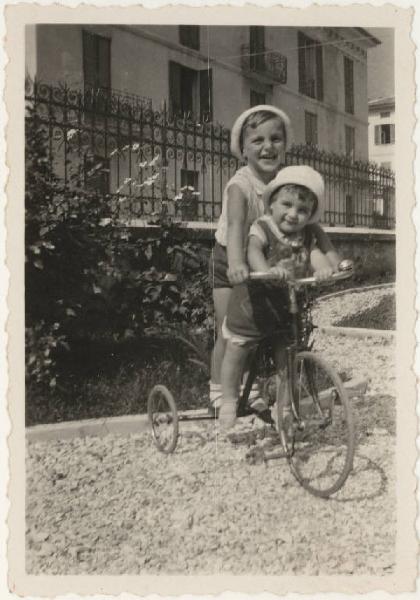 Ritratto infantile - Giacinto e Marisa sul triciclo in giardino