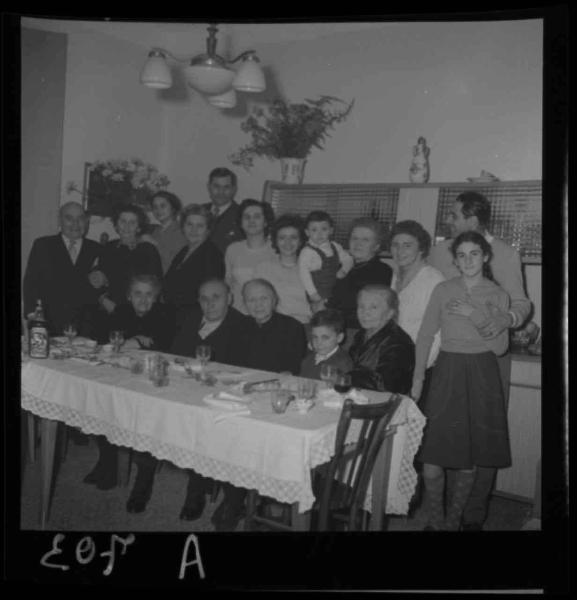 Ritratto di gruppo - Famiglia Bonventi - Adulti e bambini in posa dietro alla tavola apparecchiata