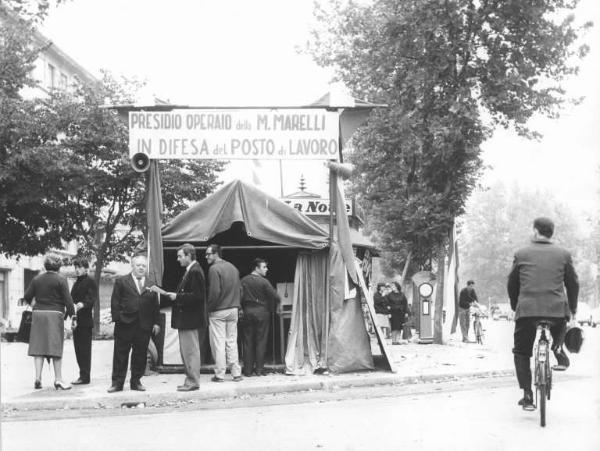 Magneti Marelli - Presidio operaio davanti alla fabbrica in difesa del posto di lavoro - Tenda dei lavoratori - Lavoratori parlano con i passanti - Striscione