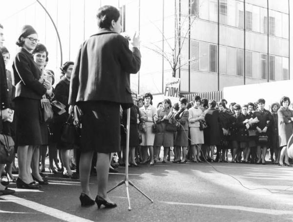 Sciopero dei lavoratori della Sit Siemens - Comizio davanti alla fabbrica - Donna al microfono - Lavoratrici - Cartello Fiom