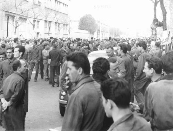 Sciopero dei lavoratori dell'Alfa Romeo - Stabilimento del Portello - Presidio davanti alla fabbrica - Operai con tuta da lavoro - Cartello Fiom e Fim Cisl