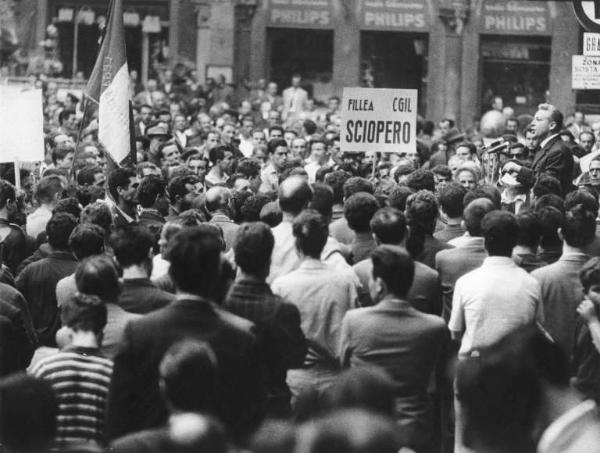 Sciopero dei lavoratori edili - Piazza Mercanti - Comizio - Oratore al microfono - Lavoratori - Cartello Fillea Cgil - Bandiera