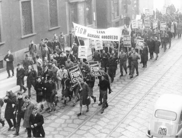 Sciopero unitario dei lavoratori metalmeccanici per il contratto - Corteo in corso di Porta Romana - Operai con tuta da lavoro - Striscione Fiom Lega Romana Rogoredo - Cartelli di sciopero Fiom e Fim Cgil