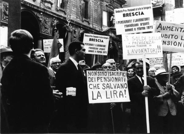 Manifestazione dei pensionati indetta dalla Camera del Lavoro - Piazza Mercanti - Anziani al comizio - Pensionati di Brescia - Cartelli di protesta