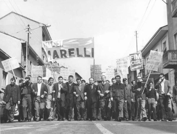 Sciopero dei lavoratori della Magneti Marelli - Testa del corteo - Operai con tuta da lavoro - Fischietti - Striscione - Cartelli di protesta - Cartelli di sciopero Fim Cisl