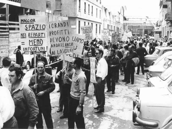 Sciopero dei lavoratori della Ferrotubi per l'orario di lavoro - Corteo davanti all'ingresso della fabbrica - Operai con tuta da lavoro - Cartelli di protesta