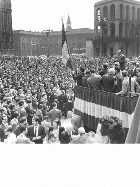 Manifestazione del primo maggio - Piazza del Duomo - Comizio - Aldo Bonaccini al microfono - Folla di manifestanti - Bandiera