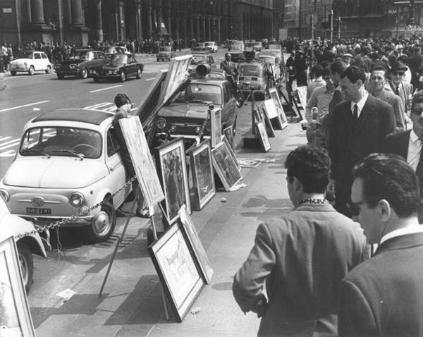 Manifestazione del primo maggio - Piazza del Duomo - Esposizione dei quadri della terza mostra di pittura e disegno indetta dalla Camera del Lavoro di Milano - Passanti osservano i quadri