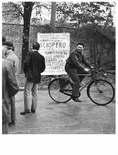 Sciopero dei lavoratori della Breda - Lavoratori escono dalla fabbrica - Operaio con tuta da lavoro in bicicletta - Cartello di sciopero Fiom, Fim, Uilm