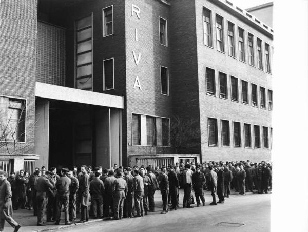 Sciopero dei lavoratori della Riva Calzoni - Presidio davanti all'ingresso della fabbrica - Operai con tuta da lavoro - Insegna Riva