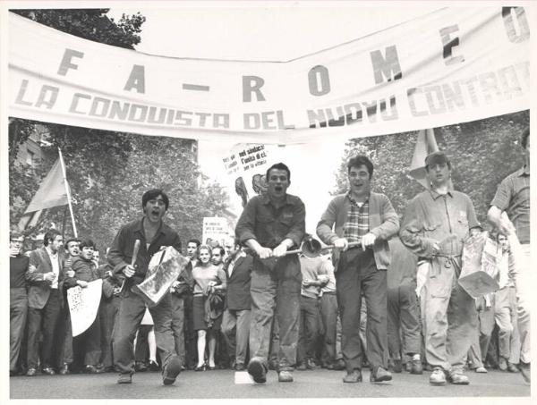 Sciopero dei lavoratori metallurgici per il rinnovo del contratto - Corteo - Spezzone lavoratori dell'Alfa Romeo - Operai con tuta da lavoro - Striscione - Cartelli di protesta - Bandiere - Campanacci - Tamburi