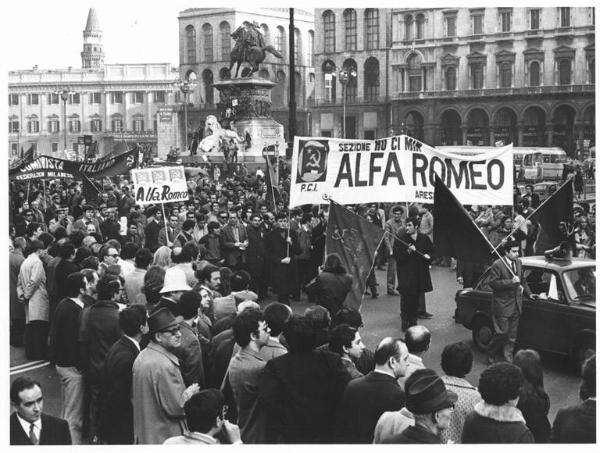 Manifestazione del partito comunista italiano (Pci) e del partito socialista italiano di unità proletaria (Psiup) contro il governo - Corteo in piazza del Duomo - Striscioni - Bandiere Pci - Auto con altoparlante - Monumento a Vittorio Emanuele II