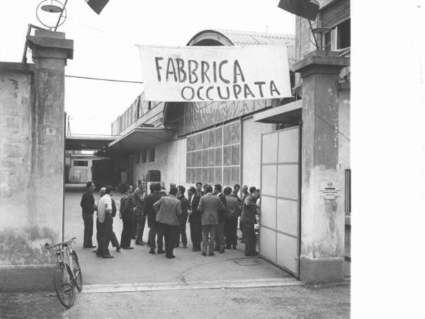 Cge - Occupazione della fabbrica contro i licenziamenti - Lavoratori nel cortile della fabbrica - Striscione