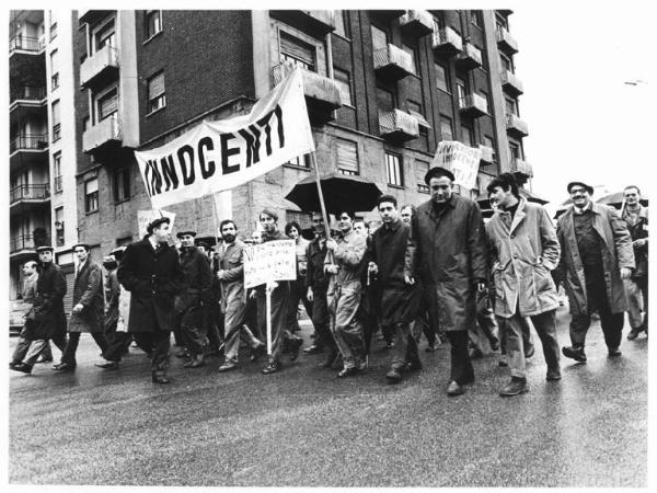 Sciopero dei lavoratori della Innocenti - Corteo verso la Prefettura sotto la pioggia - Operai con tuta da lavoro - Striscione - Cartelli