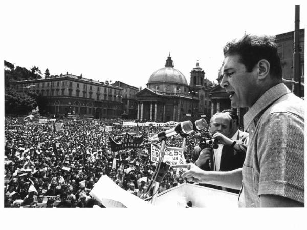 Sciopero nazionale unitario per una nuova politica economica e per lo sviluppo del Mezzogiorno - Comizio in piazza del Popolo - Palco - Luciano Lama al microfono - Folla di manifestanti - Striscioni