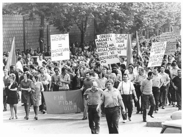 Sciopero dei lavoratori della Ercole Marelli - Corteo - Operaie con grembiule da lavoro - Bandiera Fim, Fiom, Uilm - Cartelli