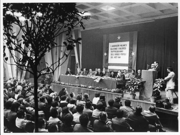 Camera del lavoro - Salone "Di Vittorio" - Interno - Incontro con la delegazione del Vietnam del Sud - Tavolo della presidenza con, tra gli altri, A. Breschi, L. Banfi, A. Pizzinato, M. Pirola - Delegato vietnamita al microfono - Parola d'ordine