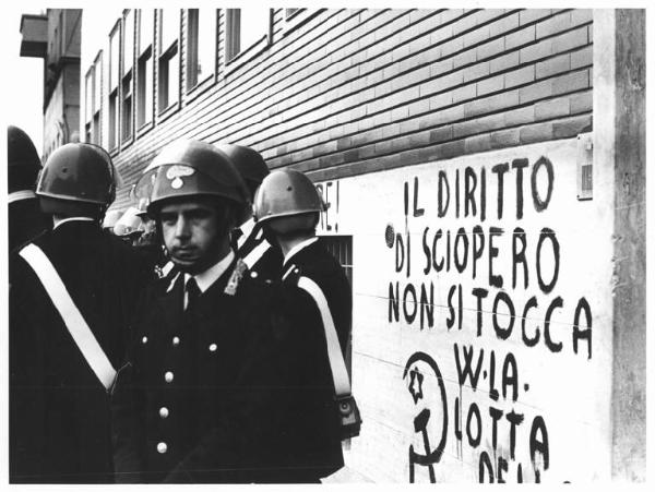 Sciopero delle lavoratrici della Crouzet - Forze dell'ordine con casco presidiano la fabbrica - Scritta sul muro della fabbrica